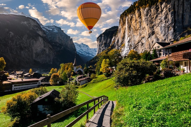 Foto mongolfiera nella valle di lauterbrunnen con una splendida cascata e le alpi svizzere sullo sfondo berner oberland svizzera europa