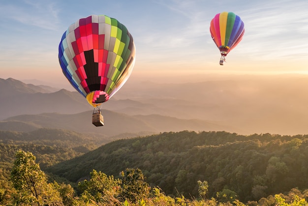 Hot air balloon over mountain at sunset