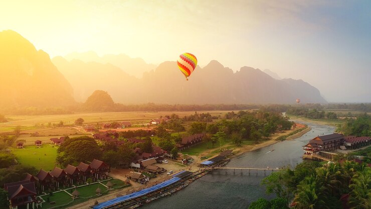 日没のVang vieng、ラオスのナムソング川の上の熱気球