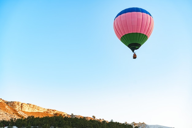 Hot air balloon with basket flying in the sky