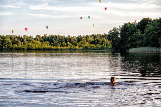 воздушные шары плывут над озером.