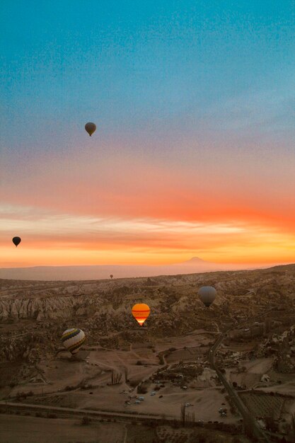 Foto palloncini ad aria calda che volano nel cielo al tramonto