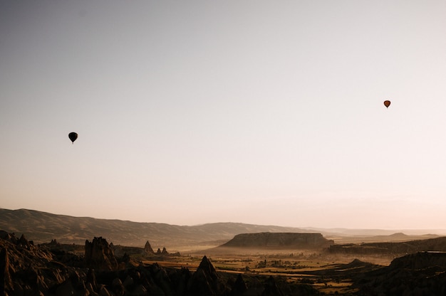 Photo hot air balloons landing in a mountain cappadocia goreme national park turkey.