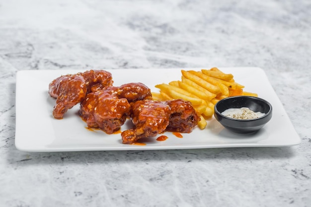 Hot and spicy buffalo chicken wings en krokante frietjes met witte saus