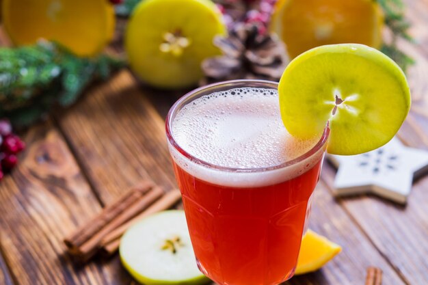 The hot apple punch in a glass on a wooden table