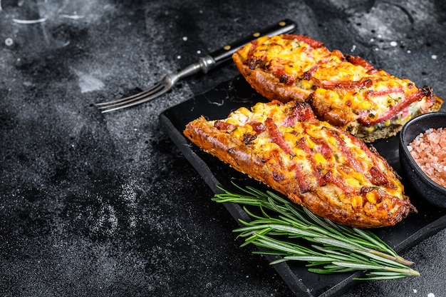 Hot baked open Baguette sandwich with ham, bacon, vegetables and cheese
