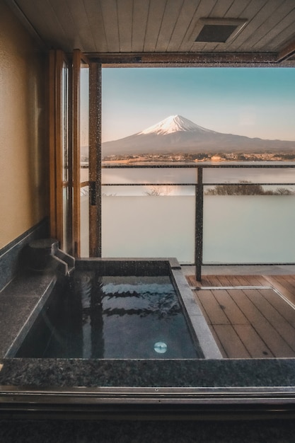 Горячая ванна японский онсэн в традиционном курорте риокан с красивым видом на гору Фудзи