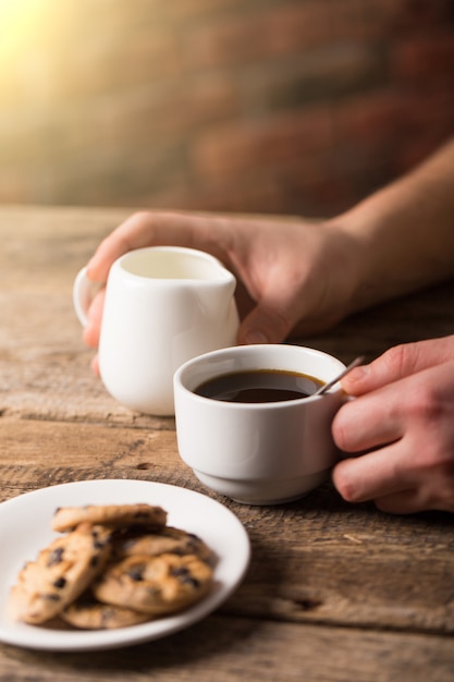 Hot black coffee with cookies and beans in cafe