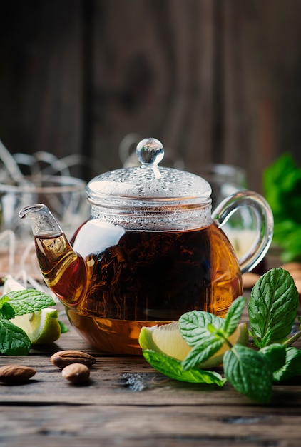 Hot black tea with lemon and mint on the wooden table