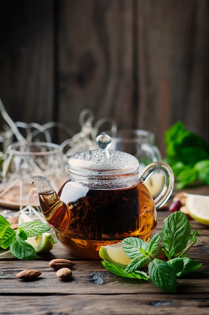 Photo hot black tea with lemon and mint on the wooden table