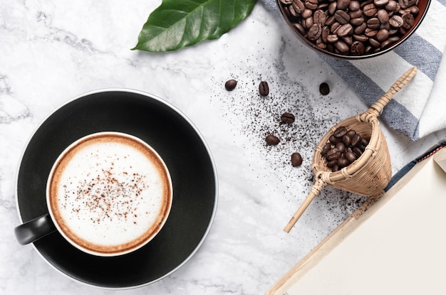 커피 원두와 뜨거운 카푸치노 커피는 대리석 테이블에 지상