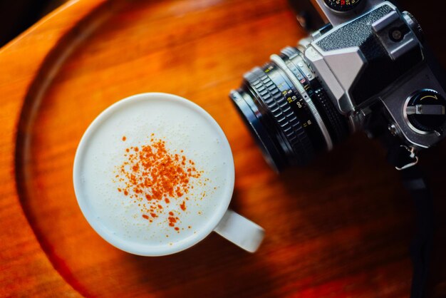 Hot cappuccino and vintage camera on wood table the drink menu cafe image