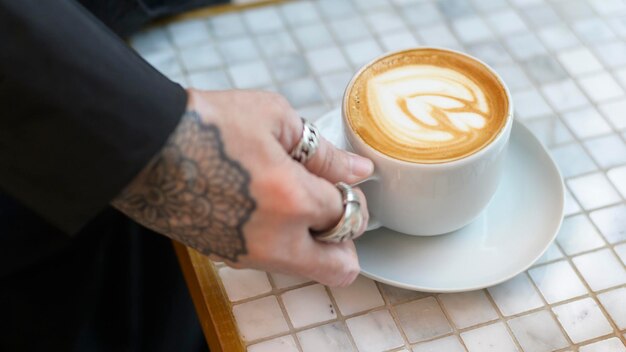 Hot cappuccino with latte art on table