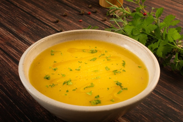 Hot cassava cream broth in a white bowl on a wooden table