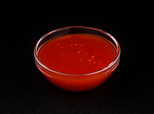 Hot chilli sauce isolated on black