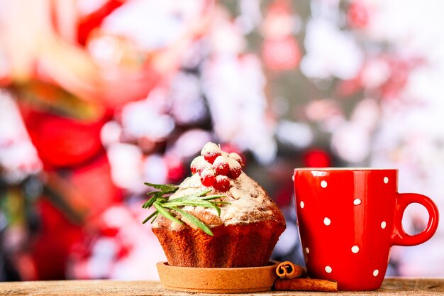 Hot chocolate on the background of a Christmas tree with a Christmas cupcakeSweets for the new year