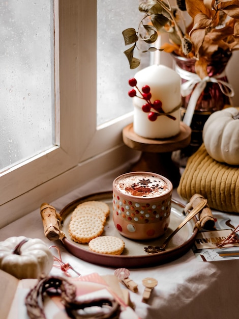 Photo hot chocolate beside the window. autumn decorations concept