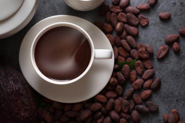 Hot chocolate and Cocoa pod cut exposing cocoa seeds on dark table