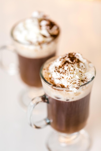 Hot chocolate garnished with whipped cream and cocoa powder.