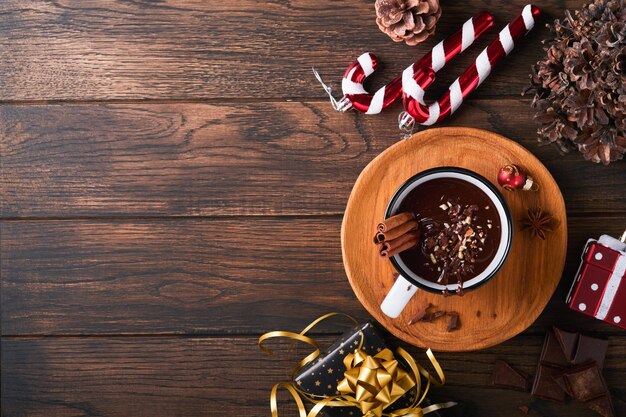 Hot chocolate Homemade spicy hot chocolate with cinnamon crushed hazelnut in enamel mug on old wooden background Cozy seasonal holidays
