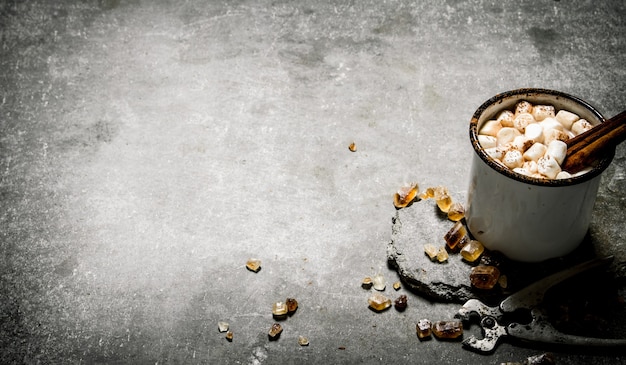 Hot chocolate with cinnamon and dark sugar. On a stone background.