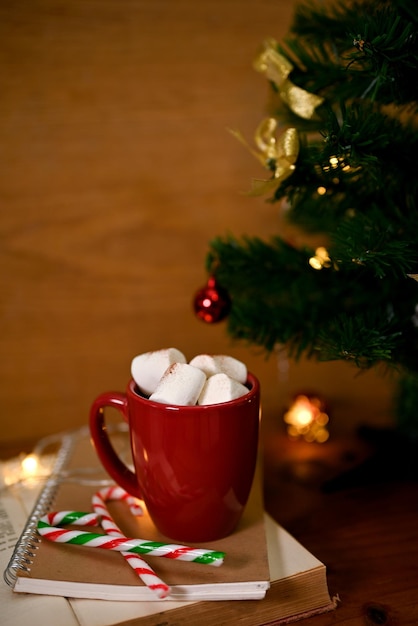 Hot chocolate with marshmallow in Christmas holiday theme in background