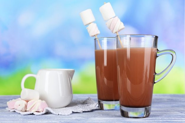 Hot chocolate with marshmallows, on blue surface