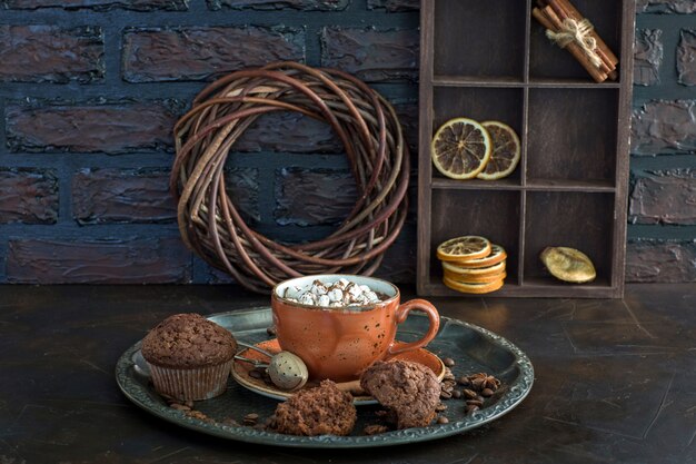 Hot chocolate with marshmallows and muffins on the table