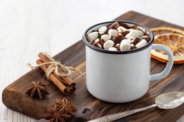 Cioccolata calda con marshmallow in una tazza vintage in metallo bianco