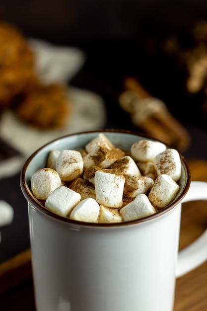 Hot chocolate with marshmallows in a white mug on a rusty