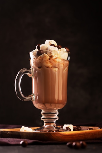 Hot chocolate with rum, cinnamon and marshmallow on dark background