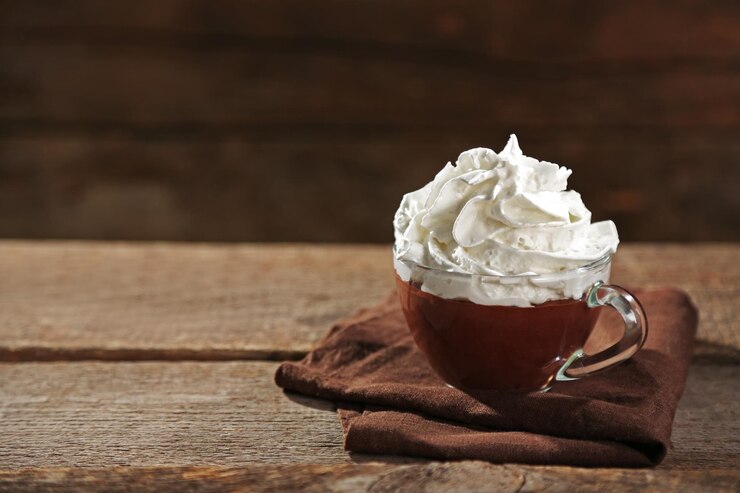 Photo 木製の背景のカップにホイップクリームでホットチョコレート
