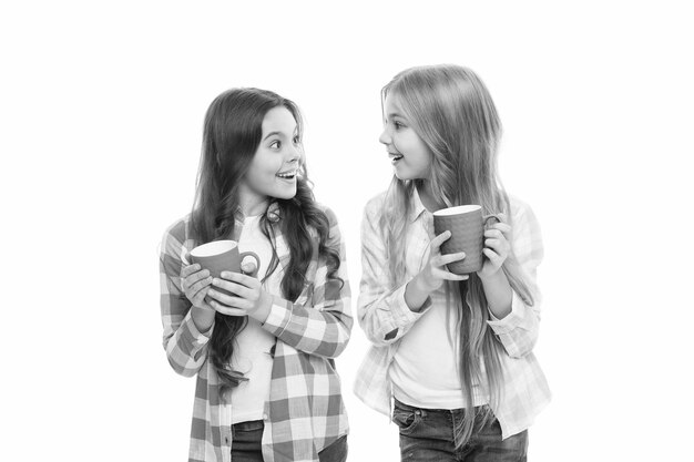 Hot cocoa recipe Make sure kids drink enough water Girls kids hold cups white background Sisters hold mugs Drinking tea juice cocoa Relaxing with drink Children drink enough during school day