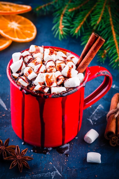 Hot cocoa with chocolate marshmallow and cinnamon in a rustic red mug