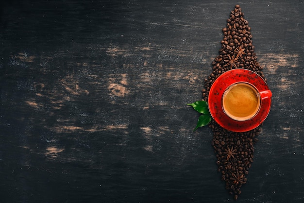 Photo hot coffee american in a cup cinnamon on a black wooden background top view copy space