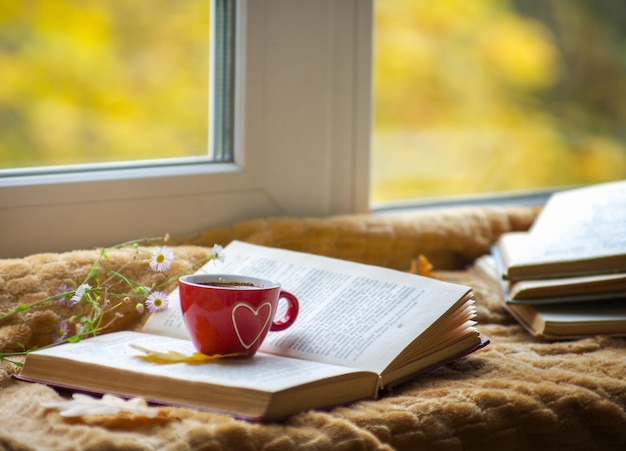 Hot coffee in the background of a window and autumn nature