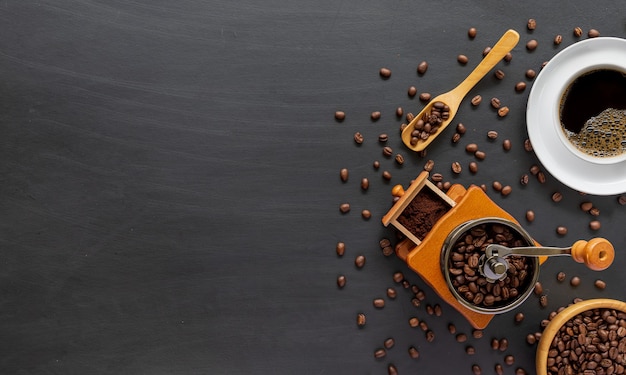 Hot coffee, bean and hand grinder on cement floor