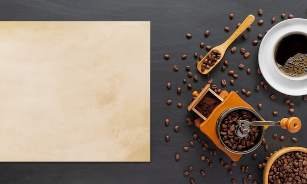 Hot coffee, bean and hand grinder on white table background. space for text. top view