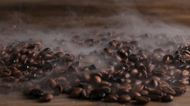 Foto chicchi di caffè caldi sul tavolo di legno