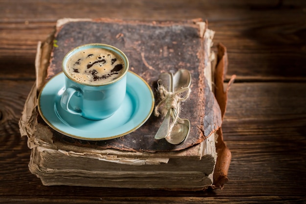 図書館の本に青い磁器のホット コーヒー