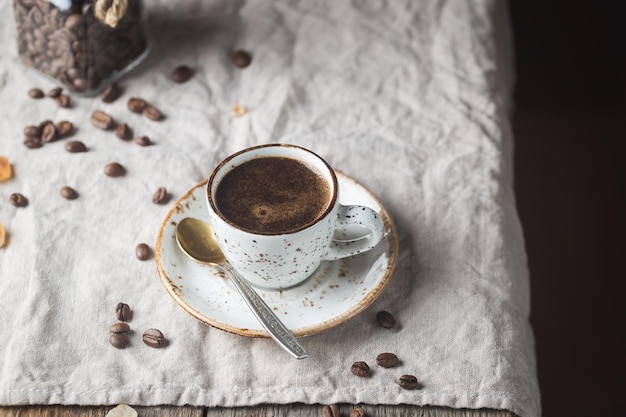 Hot Coffee cup and coffee beans on the wooden table, rustic style