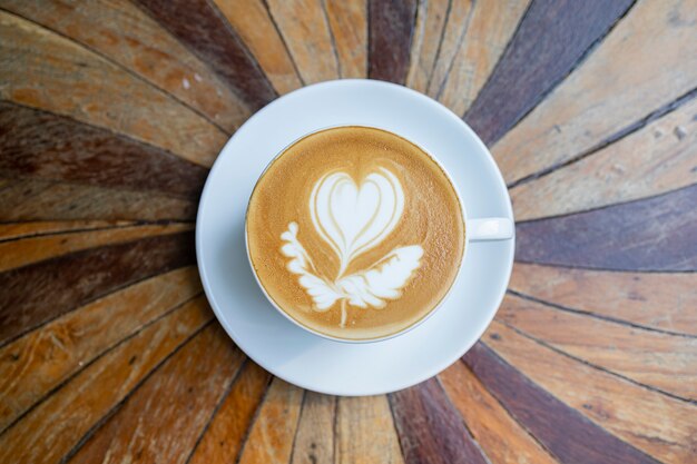 Hot coffee in a cup on wooden table, latte art