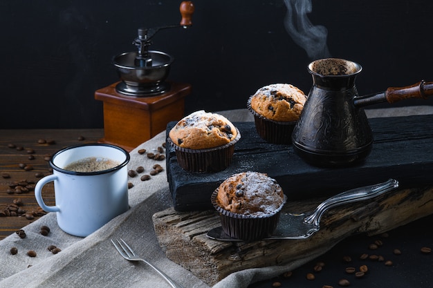 hot coffee and cupcakes on wooden planks, rustic style