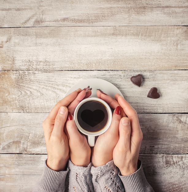 愛する人の手の中にホットコーヒー。