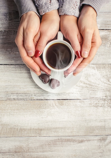 愛する人の手の中にホットコーヒー。