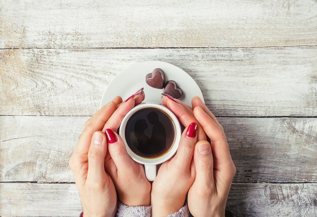 愛する人の手の中にホットコーヒー。