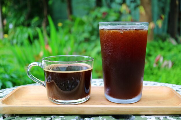 Hot Coffee and Iced Coffee in on Wooden Tray Served on Garden Table