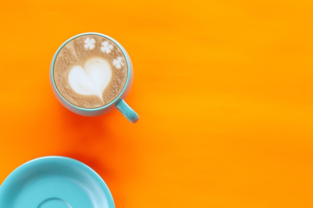 Photo hot coffee latte art heart on color background.