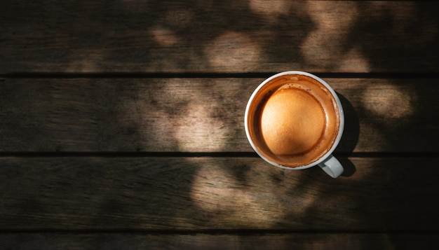 Hot Coffee Latte Cup on Wooden Table under with Natural Light. 