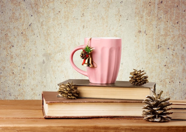 Hot coffee in pink cup with books on vintage background